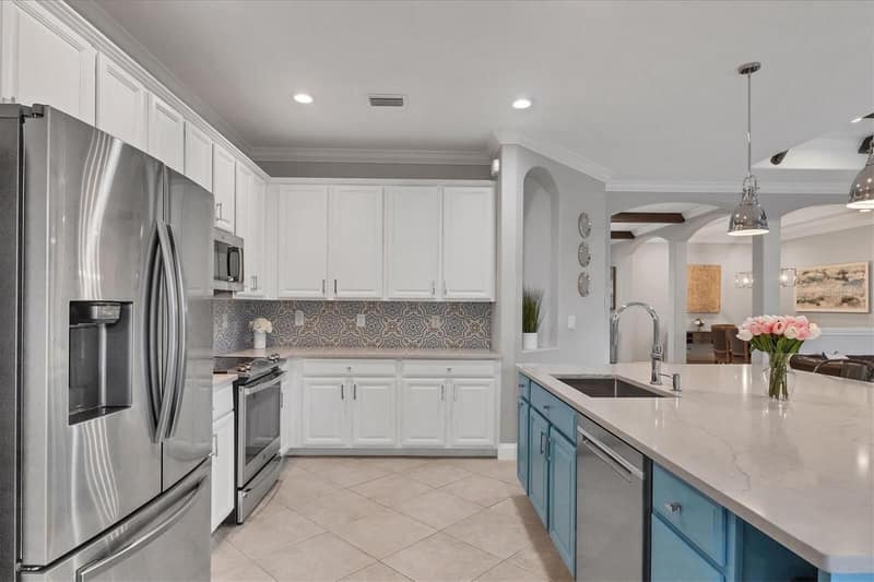 Kitchen with island, white cabinets and a blue accent wall