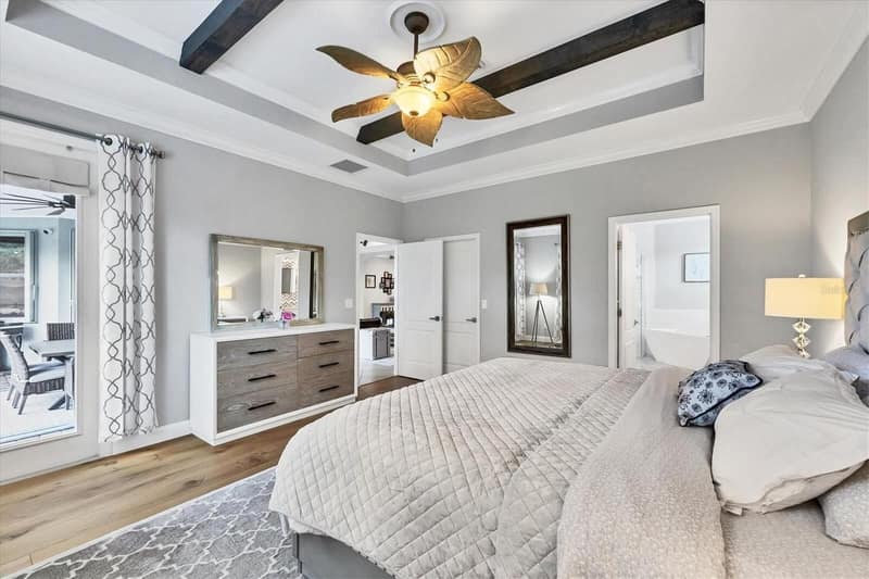 Bedroom with ceiling fan, dresser and mirror