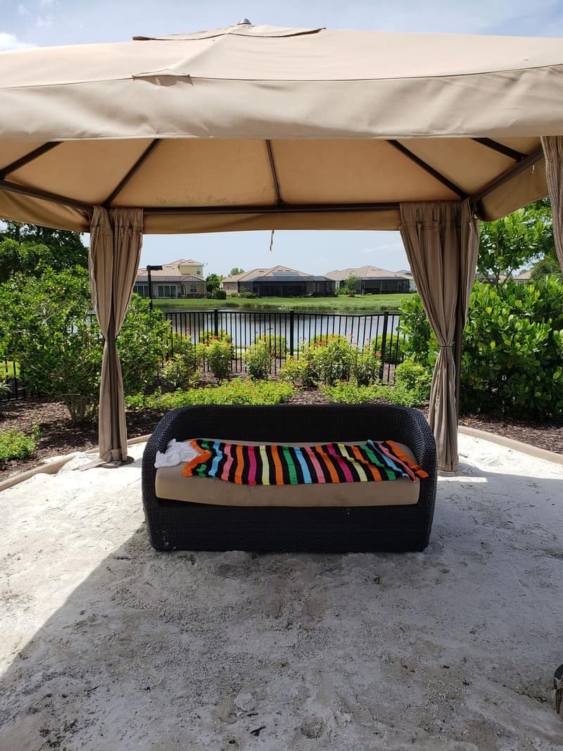 Screened porch with cushioned bench, looking over the water